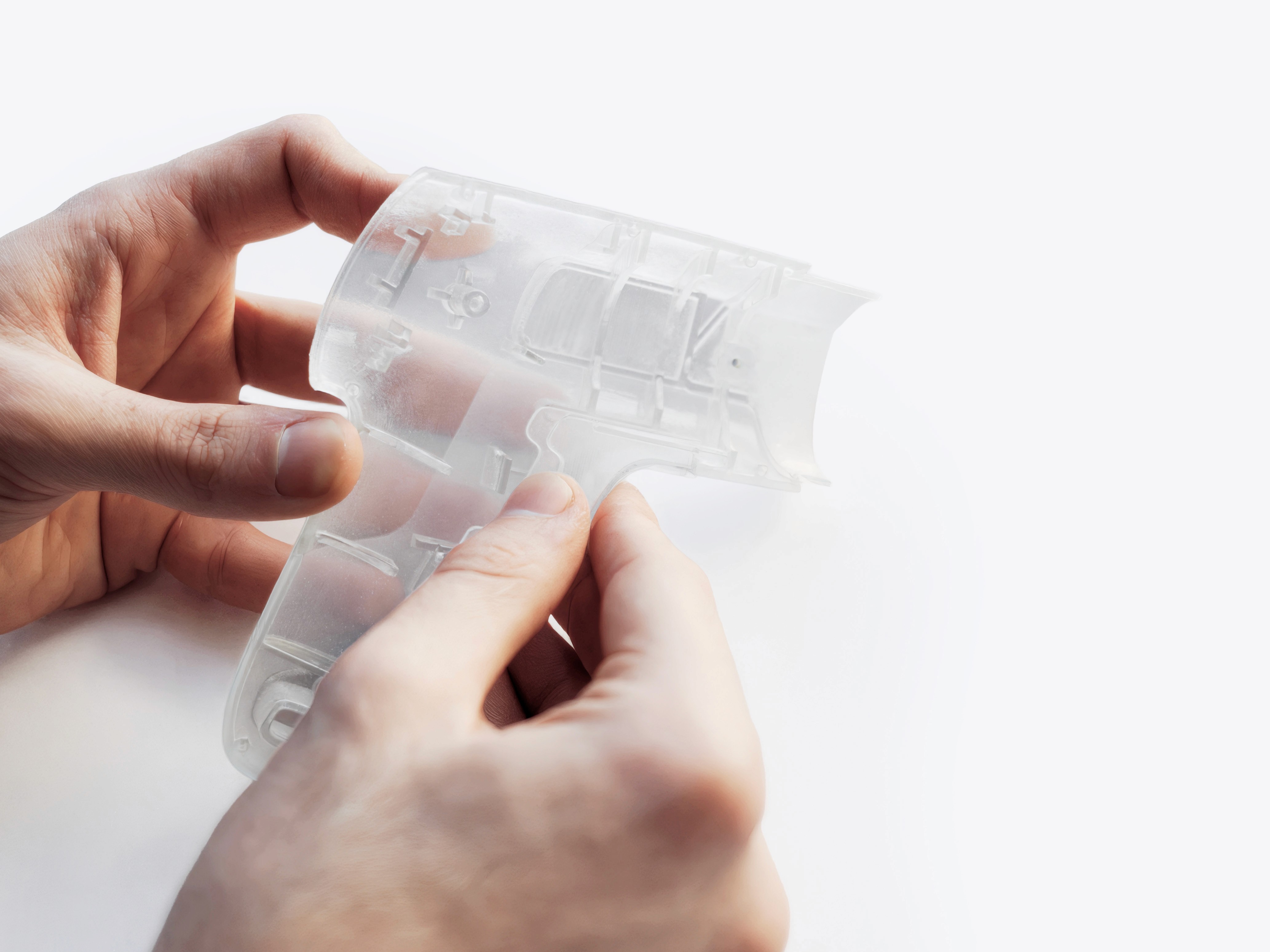 Hands examining 3D printed transparent prototype shell of Pro Mini
